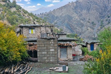 Traditional rural life in a Kurdish village, featuring a weathered stone and wood shelter and a dirt path