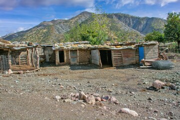 Traditional rural life in a Kurdish village, featuring a weathered stone and wood shelter and a dirt path