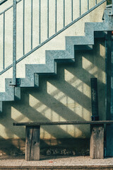 Wooden bench and metallic staircase on a farm, rustic rural scene with functional outdoor seating and architectural detail.