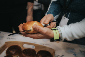 Close-up view of multiple golden brown bread rolls arranged on wooden trays, freshly baked and ready for serving on a kitchen counter.