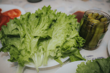 crisp green lettuce leaves and thin onion slices arranged on a white plate, with cheddar cheese slices visible in the background.