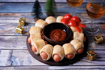 Sausages in dough in the form of Christmas wreath with ketchup sauce for Christmas holidays