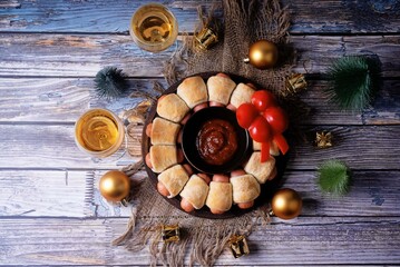 Sausages in dough in the form of Christmas wreath with ketchup sauce for Christmas holidays