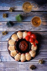 Sausages in dough in the form of Christmas wreath with ketchup sauce for Christmas holidays