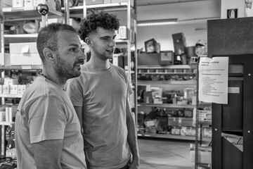 Fototapeta premium Warehouse workers selecting equipment parts from storage shelves during daily operations