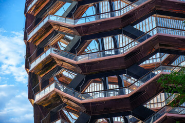 The illuminated Vessel at Hudson Yards against New York City's modern skyscrapers. A must-visit architectural marvel.