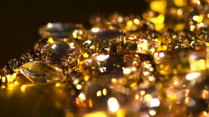 Gold crystals background, gemstones, Sew-on Stones, rhinestones for clothes, blinking gems on black background, rotating backdrop. Closeup.   - Powered by Adobe