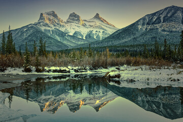 Three sisters reflection on pond at sunset