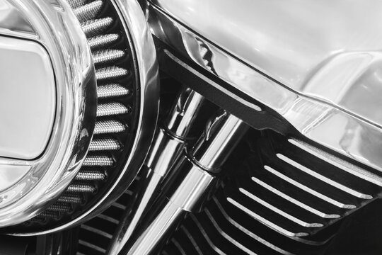A motorcycle headlight with shiny chrome finish is on front of motorcycle. headlight is a crucial component of the motorcycle, as it provides illumination for the rider to see the road ahead. - Powered by Adobe