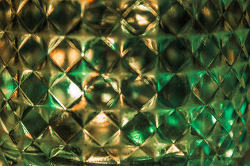 Alcohol glass, close-up, geometric rhombus shape, green and yellow backlight