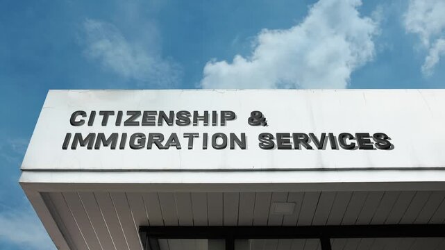 Citizenship and Immigration Services word sign displayed on the official government facade beneath a clear blue sky, signifying a facility for naturalization and immigration processing