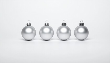 silver Christmas ornaments—three matte and one reflective—arranged in a row on a white surface.