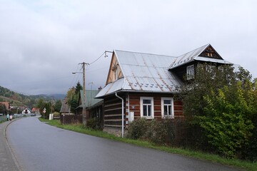 Scenery of Lupuszna village with traditional wooden buildings by street, Malopolska, Gorce Mountains, Poland