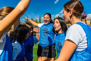 Women's soccer team huddling, celebrating success and teamwork
