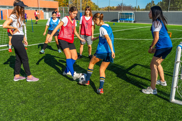 Female soccer team players training on artificial turf field