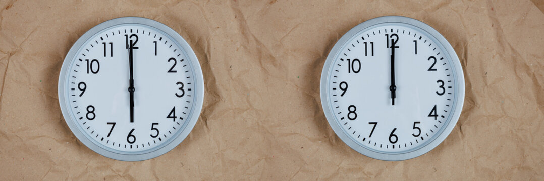 Top view: Two round clocks show six and twelve o'clock against a background of crumpled Christmas and New Year's wrapping paper. The time is morning, noon, or evening, midnight. Space for text.