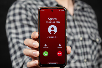 a man showing a smartphone with a warning of a spam incoming call