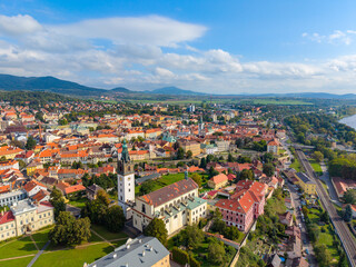 Aerial view captures St. Stephen's Cathedral standing tall in Litomerice, Czechia. Surrounding buildings and lush landscape create a beautiful scene during clear weather.