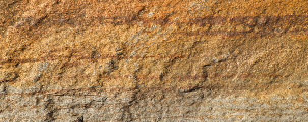 Natural brown stone surface with layered texture close-up