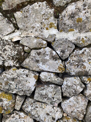 Close-up of rustic stone wall with natural textures and mossy details