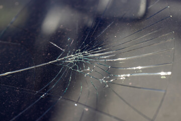 the cracked glass of a car after a road accident, the details of the windshield of a car cracked...