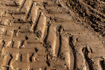 traces of a tractor on the soil of a field during tillage, soil with traces of passing heavy agricultural machinery after tillage
