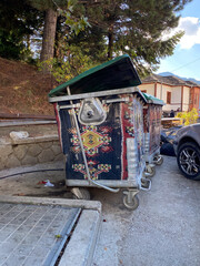 Outdoor trash bins with carpets against stone wall outdoors
