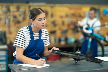 Young woman bicycle repair service worker in uniform signs agreement