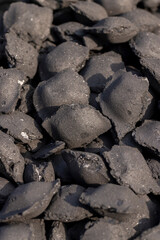 charcoal compressed from crumbs is obtained under pressure and used to light a fire and cook food on the grill, black charcoal in briquettes for barbecues and grills