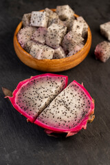 ripe red pitaya cut in half with lots of small black seeds and white soft sweet flesh inside, sweet ripe dragon fruit with black small seeds