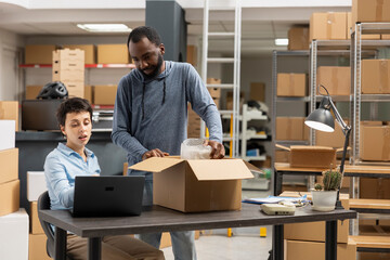 Employees team coordinating product packaging and local shipment in a supply room filled with boxes and goods, showing the daily workflow in a small scale logistics operation.