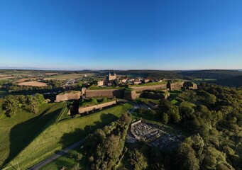 Obraz premium les remparts de la citadelle de Montmédy dans la Meuse, en Lorraine. vue aérienne panoramique en fin de journée avec un ciel bleu et des reflets dorés sur les pierres de la muraille.