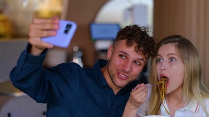 Young couple on a date taking selfie photo while eating pasta in restaurant - Powered by Adobe