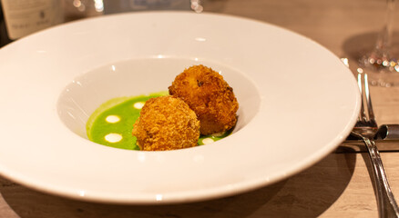 Plato servido con crocantes de carne de ternera y pollo y salsa de aguacate y crema. Gastronomía gourmet. Restaurantes de categoría.