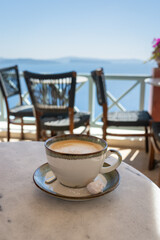 Aromática taza de café en la mesa y al fondo el mar azul soñado de las islas griegas. Imagen con desenfoque. La alegría de viajar