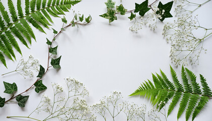Botanical flat lay-arrangement of fresh green ferns, ivy, and white flowers on a clean white background, forming a natural frame for serene designs