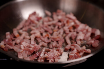 close-up of raw bacon strips in a stainless steel frying pan ready for cooking, highlighting texture and freshness in culinary preparation, heating, frying, slice, glistening, warmth, juicy, striped