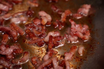 close-up of sizzling bacon strips in a hot frying pan, showcasing rich textures and glistening oil as it cooks to a crisp, evoking savory aromas and a sense of warmth in the kitchen, homely, hearty