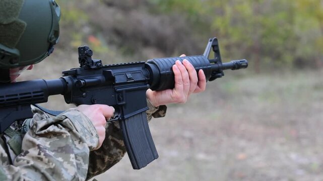 Close-up of a soldier firing an assault rifle. Concept for modern warfare, combat training, and disciplined focus.