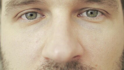 Eyes of sad young man looking at camera. Eye care, vision concept. Slow motion