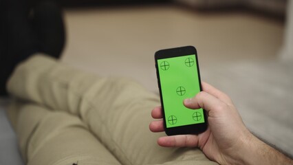 Young man resting and using mobile phone and doing swiping, scrolling gestures