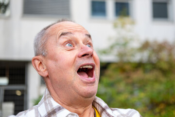 close-up man’s face screaming with wide-open mouth, intense expression, Person shouting in pain,...