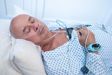 elderly man with sleep apnea monitoring device and fingertip pulse oximeter, senior male patient health tracker, adolescent sleep study equipment, breathing disorder research concept