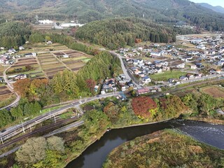 Obraz premium A town with a river running through it. The houses are spread out and there are many trees