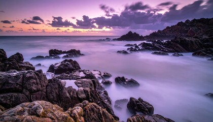 Dramatic Twilight Over Rocky Shoreline with Ethereal Purple Hues and Gentle Waves Washing Over Jagged Rocks