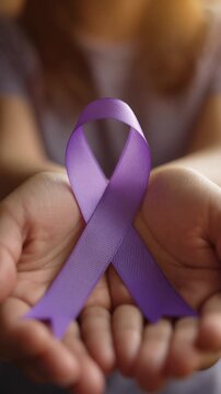 Woman&rsquo;s Hands Holding Purple Ribbon: Awareness for Gender Violence, Cancer, Alzheimer&rsquo;s, Epilepsy and Spiritual Strength. World Cancer Day