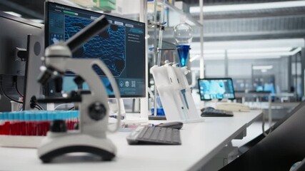 Close up of microscope in lab next to computer monitor displaying DNA data and molecular analysis interface in laboratory. Bioinformatics genomics software on PC and optical device in sterile lab - Powered by Adobe