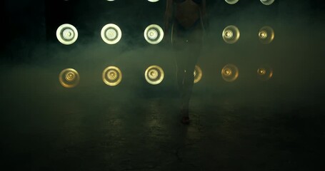 Bikini fitness presentations highlight the art of posing during competitions. The stage features vibrant lighting while competitors stand confidently amid a smoky backdrop.
