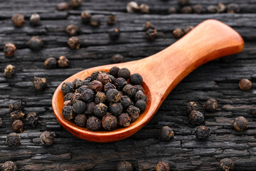 Black peppercorns in a wooden spoon - Piper nigrum