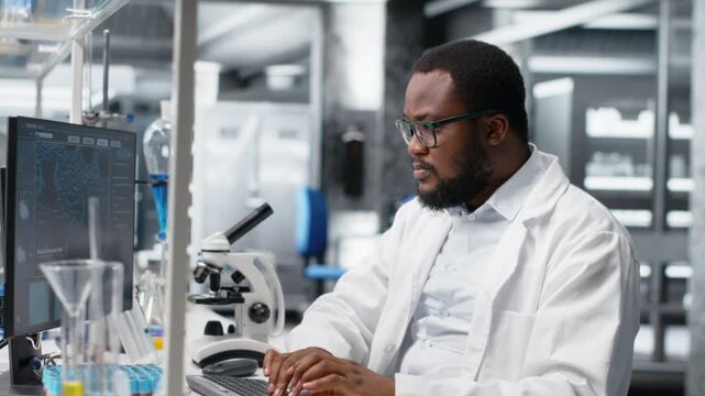 Laboratory worker squinting eyes at computer monitor, struggling to understand DNA data. African american lab expert unable to believe eyes while looking at genetic analysis diagnostics, camera B